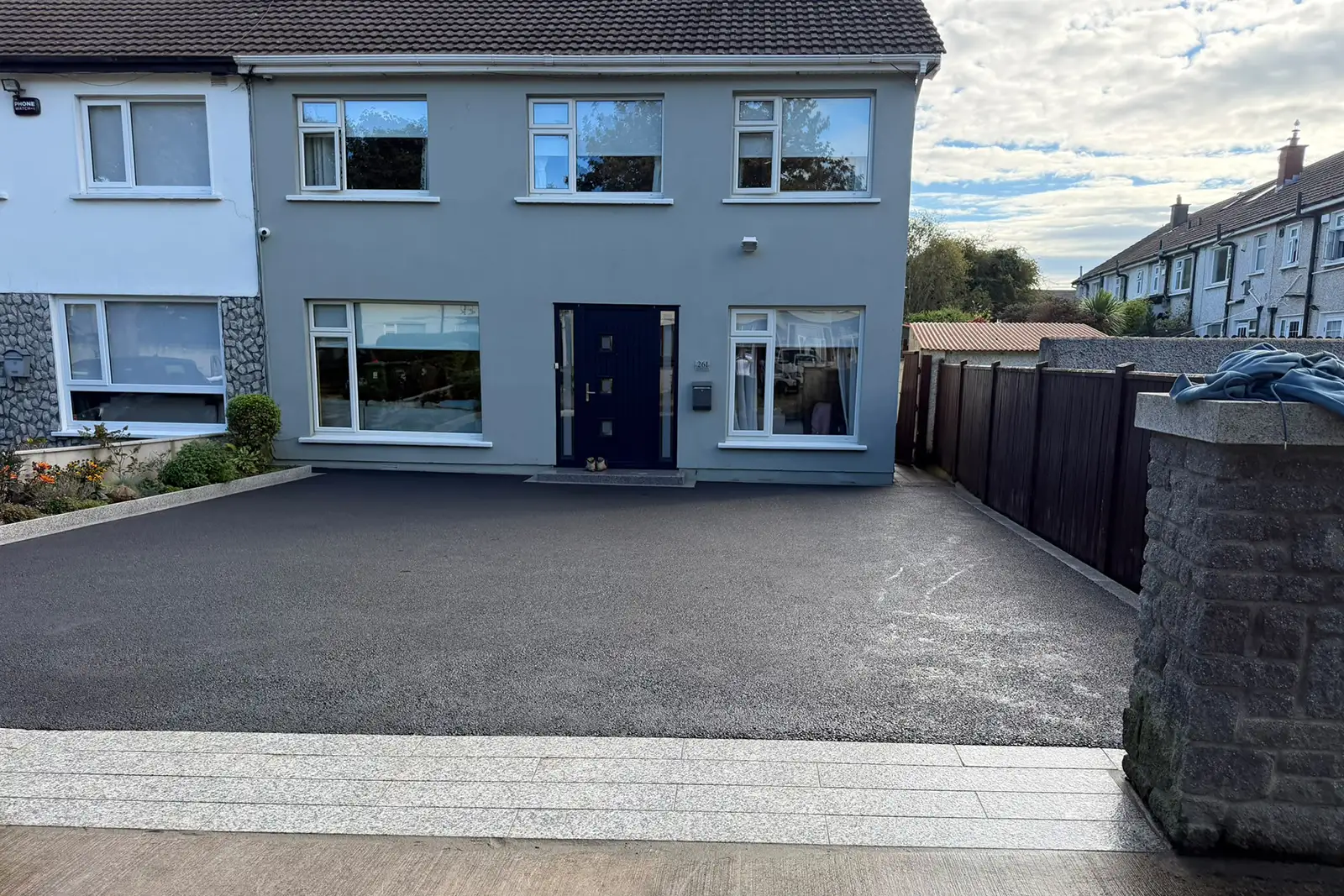Completed SMA tarmac driveway with silver granite framing planting area risers and a granite step in Balrothery North Dublin