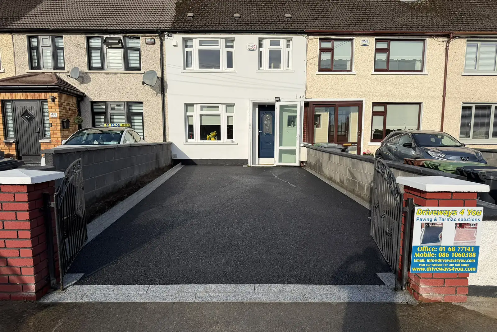 Completed SMA tarmac driveway with natural granite framing stone entrance blocks and planting area risers at Loretto Crescent Rathfarnham