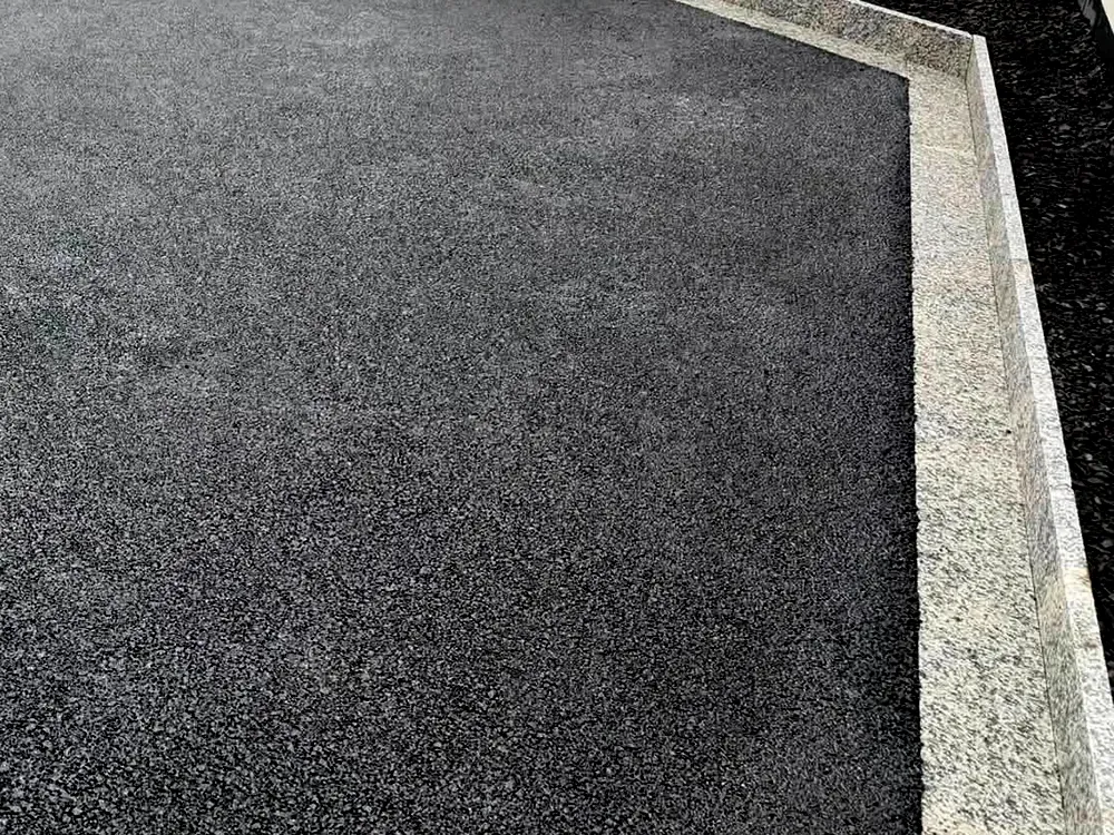 Granite block edging around a tarmac driveway