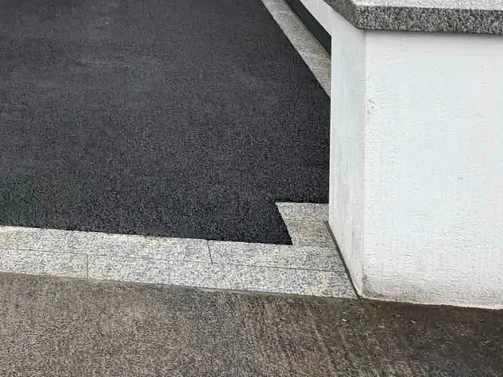 Paving border alongside a tarmac driveway